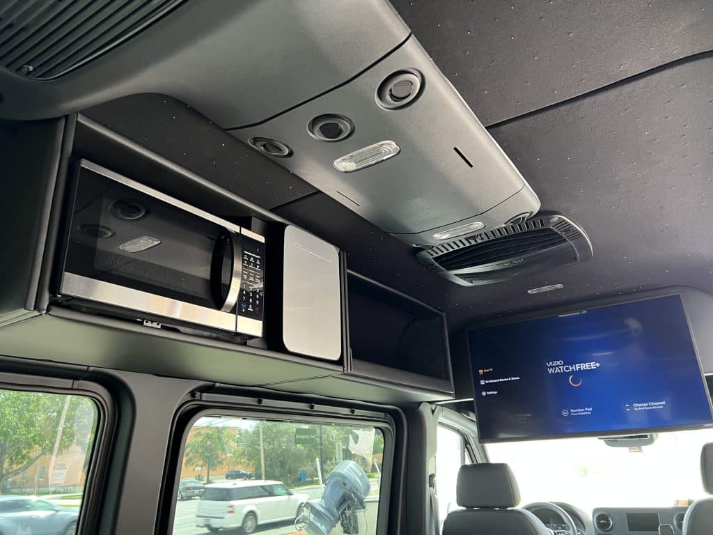 Roof of live-in van with microwave and large TV screen installed
